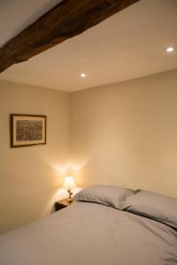 a bedroom with a bed and a lamp on a table at 138a Old Star & Garter in Ludlow