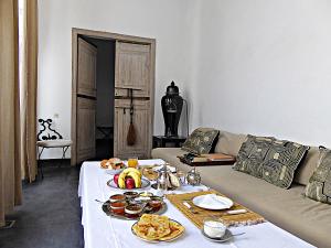 a living room with a table with food on a couch at Dar Seven in Marrakesh