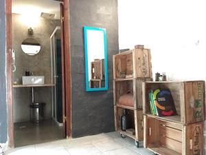 a room with a mirror on a wall and a shelf at MedioMundo Hostel in Montevideo