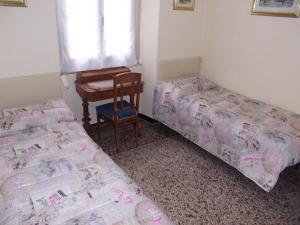 a bedroom with two beds and a desk and a table at Casa Iaia in Genova