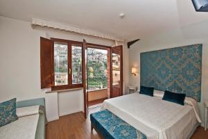 1 dormitorio con cama y ventana en Hotel Alma Domus, en Siena
