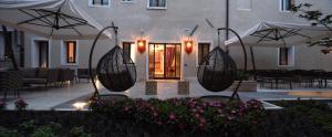 a patio with two hanging baskets in front of a building at Santa Croce Boutique Hotel in Venice +37 photos