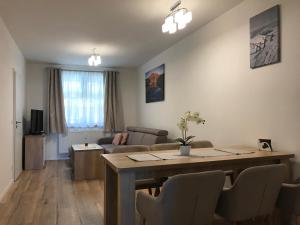 a living room with a table and a couch at Apartmán B3 Biela Púť - Jasná in Belá