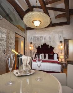 a bedroom with a bed and a table with wine glasses at Santa Croce Boutique Hotel in Venice