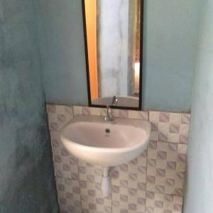 a white sink in a bathroom with a mirror at Landak River Guest House Jungle Trekking Only Booking with Us in Bukit Lawang