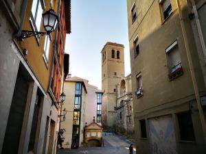 an alley with a clock tower in a city at El Capricho de Sagasta in Logroño