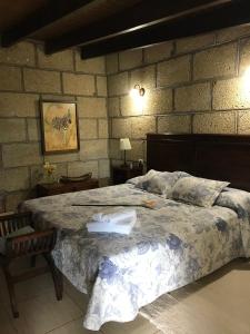 サンミゲル・デ・アボナにあるFinca el Cortijoのレンガの壁、大きなベッド付きのベッドルーム1室