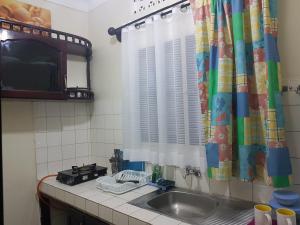 a kitchen counter with a sink and a window at Family Friendly Stay near Entebbe Airport in Entebbe