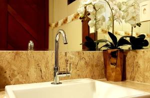 a kitchen sink with a faucet and a mirror at Casa dos Girassóis in Pipa +58 photos