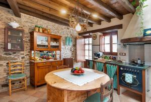 a kitchen with a table with a bowl of fruit on it at Can Baldiret, El Port de la Selva in La Vall de Santa Creu