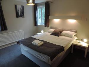 a bedroom with a large bed with two towels on it at 5 Bed Camberley Airport Accommodation in Camberley