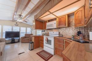 uma cozinha com armários de madeira e um forno com placa de fogão em Island Beach House with No Extra Fees em Jensen Beach