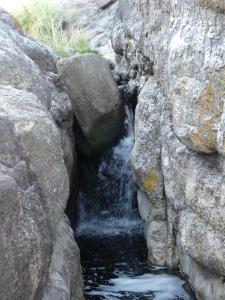 um riacho de água no meio de algumas rochas em Cabañas Pampa em Mina Clavero