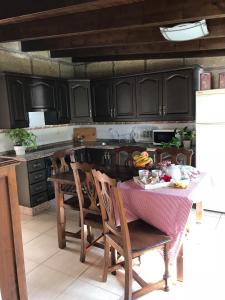 a kitchen with black cabinets and a table with food on it at Finca el Cortijo in San Miguel de Abona