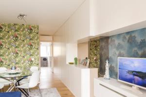 ein Wohnzimmer mit Fernseher und Esstisch in der Unterkunft Apartamento da Praia - Surf in Matosinhos