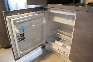 an empty refrigerator with its door open in a kitchen at Warrest - Short Rent Apartments in Milan