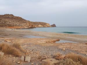 een strand met een rotsachtige kustlijn en de oceaan bij Akti Rooms in Xerokampos