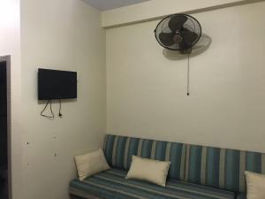 Una sala de estar con un sofá y un ventilador. en Khaqan Heights, Murree, en Murree