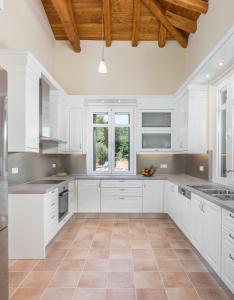 a kitchen with white cabinets and a wooden ceiling at VILLA MYLOS in Danilia +11 photos