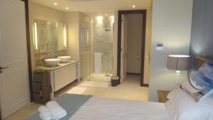 a bedroom with a bed and a bathroom with a shower at Island View Apartment by Simply-Seychelles in Eden Island