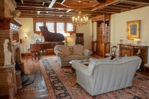 a living room with a couch and a piano at The Towers Bed & Breakfast in Milford