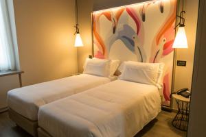 two beds in a room with a painting on the wall at Hotel San Giovanni Roma in Rome
