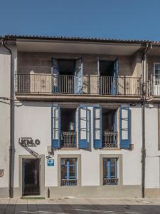 an apartment building with blue windows and balconies at Santiago KM-0 in Santiago de Compostela