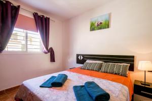 a bedroom with a bed with two blue towels on it at Orlando 85 in Adeje +20 photos