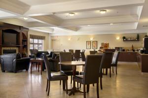 a restaurant with tables and chairs and a bar at Ramada by Wyndham High River in High River