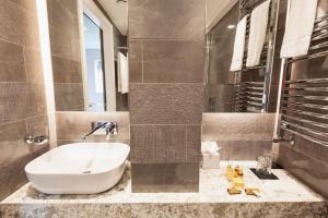 uma casa de banho com uma grande banheira branca e um lavatório. em Clarendon Suites em Dublin