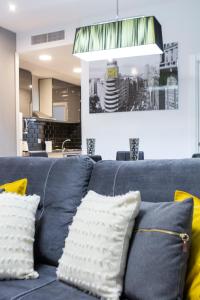 a blue couch with yellow pillows in a living room at Prado Apartment in Madrid