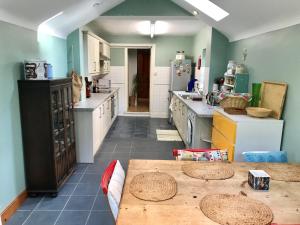 a kitchen with a table in the middle of it at Lovely Terraced 2-Bed House (near Hinksey Park) in Oxford