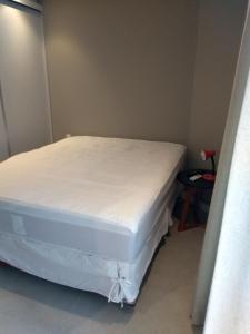 a bed in a room with a white mattress at Estacofor Santos - Apto 1105 in Santos
