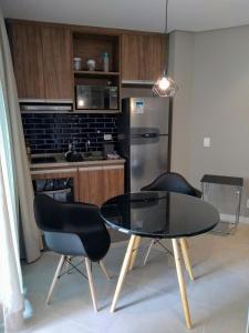 a kitchen with a table and chairs and a refrigerator at Estacofor Santos - Apto 1105 in Santos
