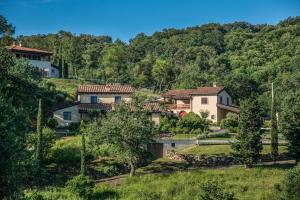 un grupo de casas en una colina con árboles en Poggio La Croce, en Scarlino
