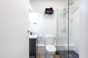 a bathroom with a toilet and a glass shower at Prado Apartment in Madrid