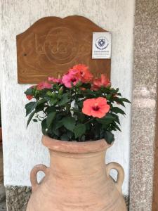 um grande vaso cheio de flores em frente a um sinal em Hotel La Rotonda em Cepagatti