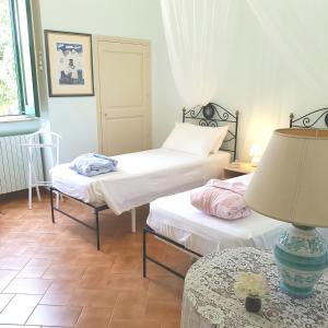 a room with two beds and a lamp on a table at Villa Edda Heated Pool in Galatina