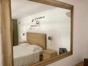 um reflexo de espelho de uma cama num quarto em Greta Viola House em Squinzano