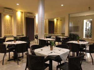 a restaurant with tables and chairs and a mirror at Hotel Sinar 1 in Sedati