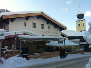 a building with a clock tower in the snow at Haus Willibald in Saalbach Hinterglemm
