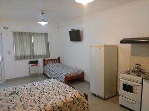 a room with two beds and a refrigerator and a stove at Los Alamos in Puiggari