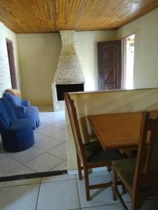 a living room with a fireplace and a table and chairs at Sitio Vale das Montanhas in São Thomé das Letras