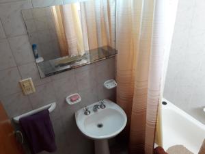 Baño pequeño con lavabo y espejo en Departamento Avda Belgrano Sur 367 con Cochera Privada en Santa Rosa