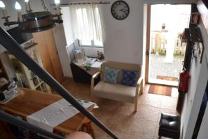 a view of a living room with a clock on the wall at Casinha de Muda da Feteira in Angra do Heroísmo