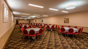 einen Konferenzraum mit Tischen und roten Stühlen in der Unterkunft Old Mill Inn in Omaha