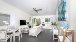 eine Küche und ein Wohnzimmer mit einem Tisch und Stühlen in der Unterkunft Mama Taras Bungalows in Rarotonga