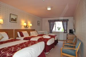 a hotel room with two beds and a television at Willowbank Hotel in Largs