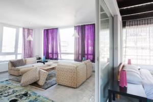 1 dormitorio con cortinas moradas, 1 cama y 1 sofá en Urban Downtown Loft, en Atenas