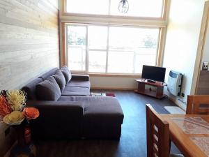 a living room with a couch and a large window at Cabañas Sur Patagón in Puerto Varas